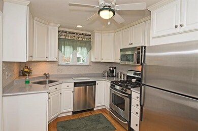 Wood floors. white cabinets, and gray solid surfac