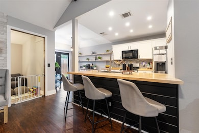 Kitchen featuring black microwave, wooden counter