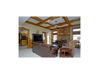 GREAT ROOM WITH BOXED BEAM CEILING AND FIREPLACE.