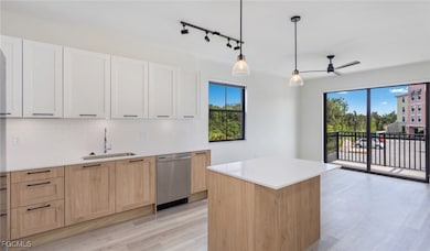Kitchen featuring a sink, stainless steel dishwasher, a wealth of natural light, and decorative backsplash