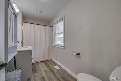 Bathroom featuring vanity, light wood-style flooring, and shower / tub combo