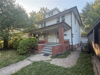 American foursquare style home featuring covered porch and a gate