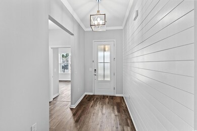 Doorway to outside with a notable chandelier, dark