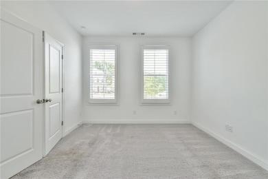 Unfurnished room featuring baseboards, light carpe