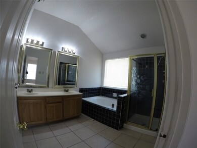 Bathroom featuring tile patterned flooring, vanity, a healthy amount of sunlight, and vaulted ceiling