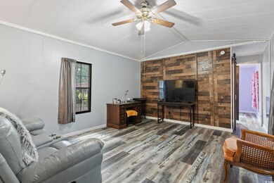 Living room with ceiling fan, ornamental molding, 