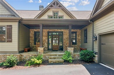 Entrance to property featuring a porch, a chimney, a shingled roof, and driveway