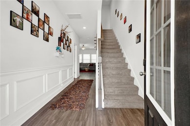 Stairway featuring recessed lighting, a ceiling fa