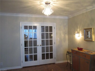 French doors separate the entry from the living space in the unit. The crystal chandelier can grace a dining room table or invite guests into the living room and dining room area.