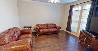 Living area with wood finished floors, ceiling fan