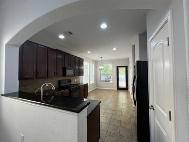 Kitchen with dark brown cabinetry, black appliances, decorative backsplash, pendant lighting, and recessed lighting
