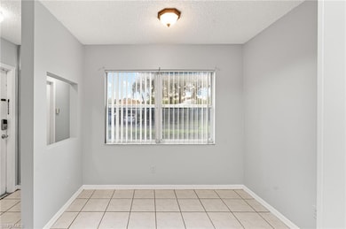 Empty room featuring a textured ceiling and light tile patterned floors