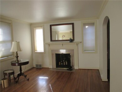 Living room with exposed wood floors, ceiling moul