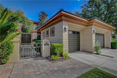 View of side of home with a gate, concrete driveway, a garage, and stucco siding