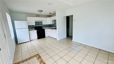 Kitchen featuring freestanding refrigerator, black range with electric stovetop, backsplash, and light tile patterned flooring