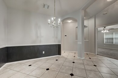 This view shows the dining room, looking toward the carpeted bonus room that has French doors for privacy.