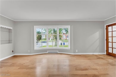 Unfurnished room featuring crown molding and light wood-style floors