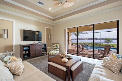 Living room with ceiling fan, ornamental molding, a raised ceiling, recessed lighting, and tile patterned floors