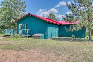 View of home's exterior featuring a metal roof, a lawn, and a deck