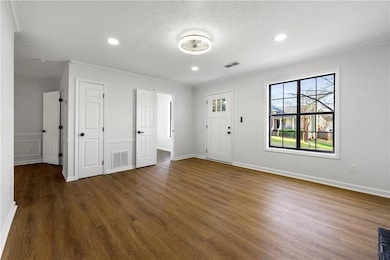Foyer featuring dark wood-style floors, healthy amount of natural light, crown molding, recessed lighting, and baseboards