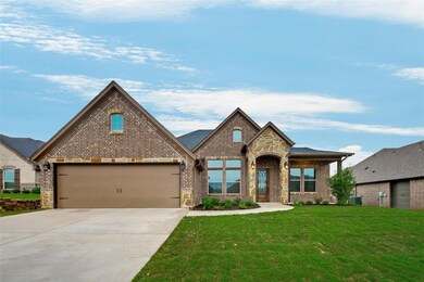 View of front of home with a front lawn, brick siding, and concrete driveway