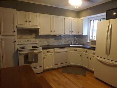Updated white kitchen with gleaming hardwoods.