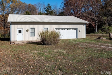 Detached garage with view of scattered trees