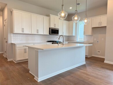Kitchen featuring stainless steel microwave, dark