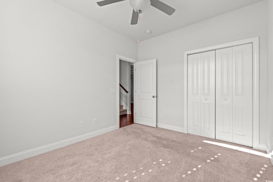 Unfurnished bedroom featuring carpet, a closet, and ceiling fan