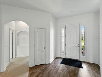 Entrance foyer and hallway to primary suite and bonus room.