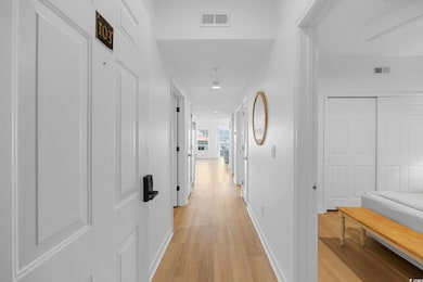 Hall with light wood finished floors, baseboards, 