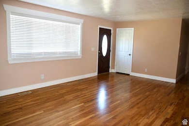 Entryway with dark wood finished floors and a textured ceiling