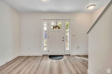 Entrance foyer with baseboards and light wood-style flooring