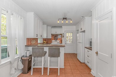 Kitchen with white cabinetry, range with electric 