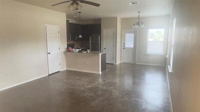 Kitchen with concrete flooring, freestanding refr