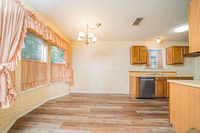 Kitchen featuring dishwasher, light wood-type floo
