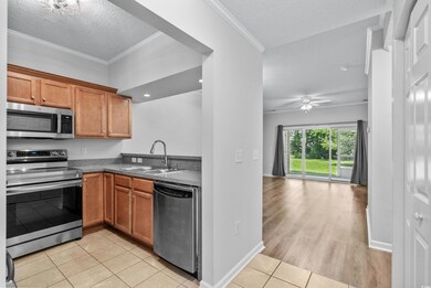 Kitchen featuring ceiling fan, crown molding, sink