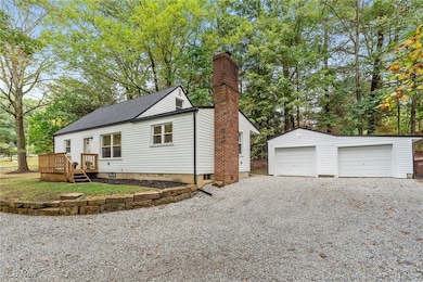 Additional view of the side of the home showing white vinyl siding and view of the garage