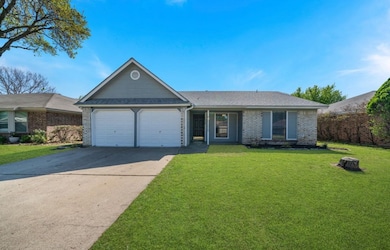 Ranch-style home with concrete driveway, brick siding, a front lawn, an attached garage, and a shingled roof