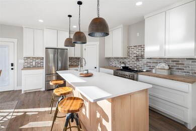 Kitchen with white cabinetry, dark wood-type floor