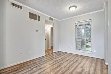 Spare room with ornamental molding, a textured cei