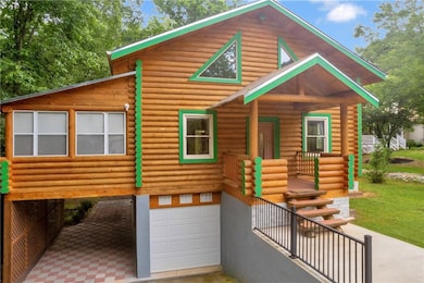 Log cabin with a garage, stairway, a porch, and log exterior