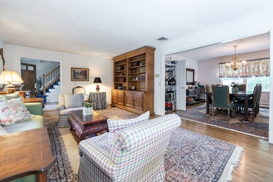 Alternate View of Living Room with Built-In Cabinetry, Hardwood Floors, Facing Formal Dining Room and Entrance Foyer
