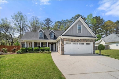 View of front facade featuring driveway, stone sid