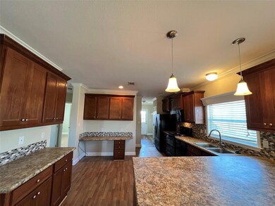 Kitchen with a sink, black appliances, backsplash