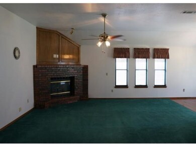 Living Room. Living Room has Ceiling Fan, Tall Ceiling & Corner Fireplace with Gas Logs