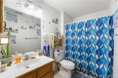 Bathroom with tile patterned flooring, toilet, vanity, and a shower with curtain