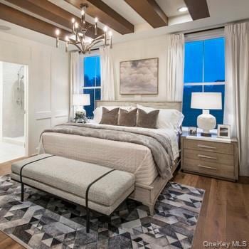 Bedroom featuring beamed ceiling, wood finished floors, a chandelier, a decorative wall, and ensuite bathroom