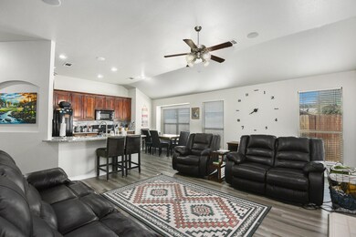 Living area featuring lofted ceiling, dark wood-style flooring, ceiling fan, and recessed lighting