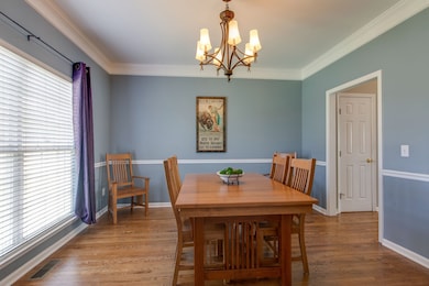 The dining room will be a favorite of your guests. Plenty of space here for a large dinner party. Your guests will enjoy the view of the lush front yard. Luxury abounds with crown molding, updated chandelier and gleaming wood floors.